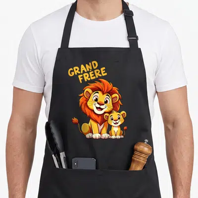 Tablier de cuisine noir avec un lion et un lionceau souriants sous l'inscription Grand Frère en lettres jaunes.