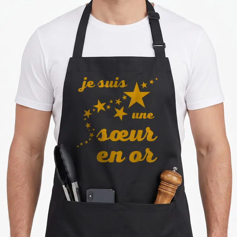 Tablier de cuisine noir avec inscription je suis une sœur en or et traînée d'étoiles dorées.
