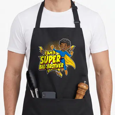 Tablier de cuisine noir avec une illustration de super-héros et le texte I am a super big brother en jaune et bleu.