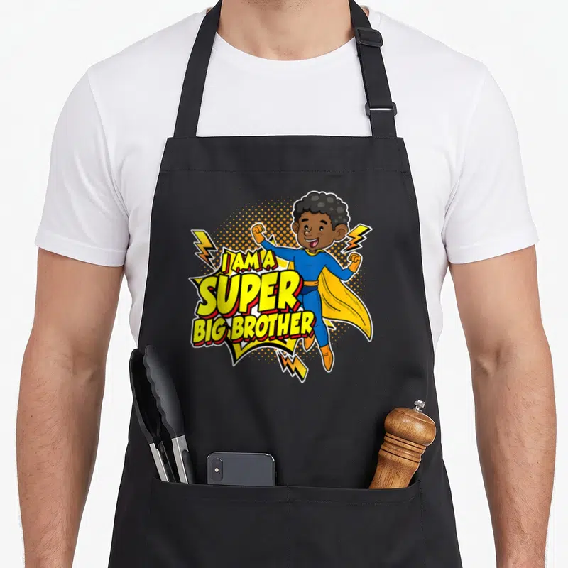 Tablier de cuisine noir avec une illustration de super-héros et le texte I am a super big brother en jaune et bleu.