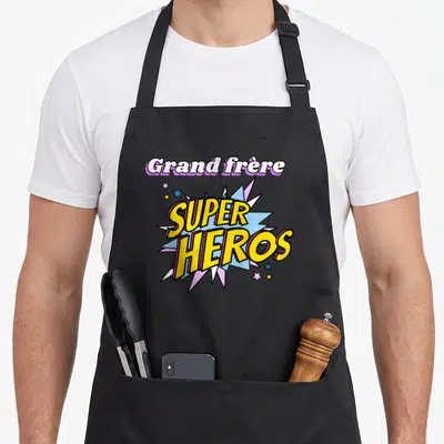 Tablier de cuisine noir avec une illustration type comics affichant Grand frère Super Héros entouré d'étoiles.