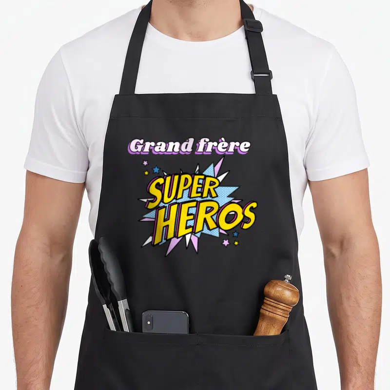 Tablier de cuisine noir avec une illustration type comics affichant Grand frère Super Héros entouré d'étoiles.