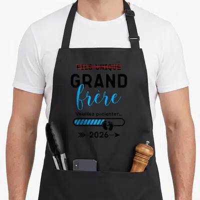 Tablier de cuisine noir avec inscription Fils Unique barré, Grand frère en bleu, barre de chargement et petits pieds noirs.
