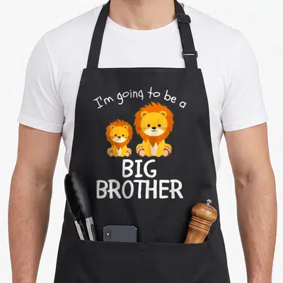 Tablier de cuisine noir avec deux lions orange et le texte I'm going to be a BIG BROTHER en blanc.