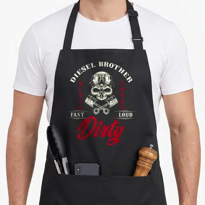 Tablier de cuisine noir avec illustration de crâne casqué, pistons croisés et texte Diesel Brother Dirty en rouge et blanc.