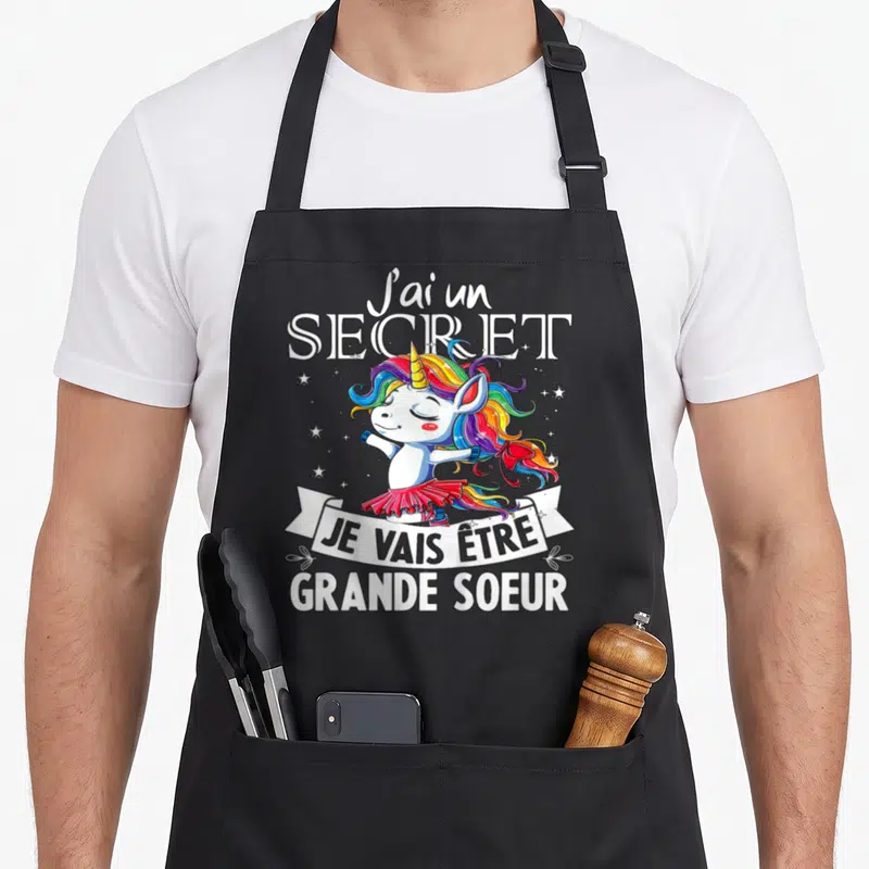 Tablier de cuisine noir avec licorne aux cheveux arc-en-ciel et texte J'ai un secret Je vais être grande soeur.