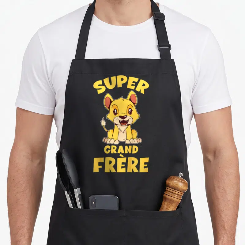 Tablier de cuisine noir avec un lionceau jaune et le texte super grand frère imprimé en lettres capitales jaunes.