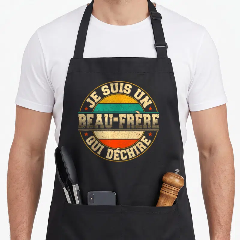Tablier de cuisine noir avec logo circulaire vintage affichant Je Suis Un Beau-Frère Qui Déchire en lettres blanches et bandes colorées.