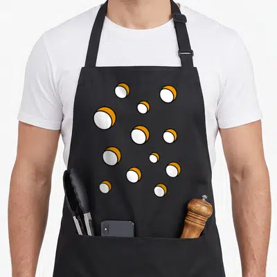 Tablier de cuisine noir avec un motif répétitif de boules blanches et jaunes représentant des fromages fondants stylisés.