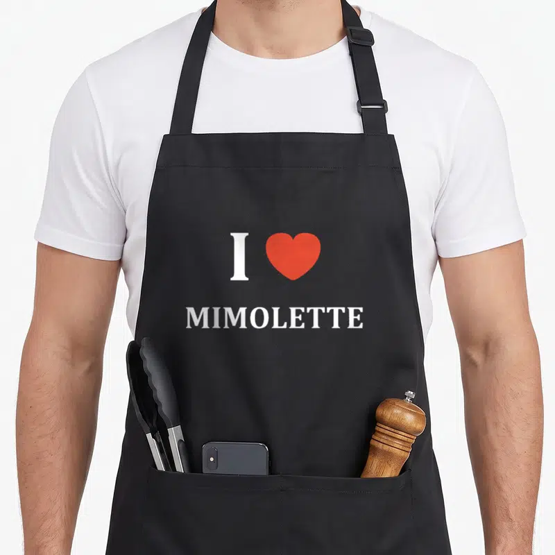 Tablier de cuisine noir avec le texte blanc I love Mimolette et un cœur rouge au centre.