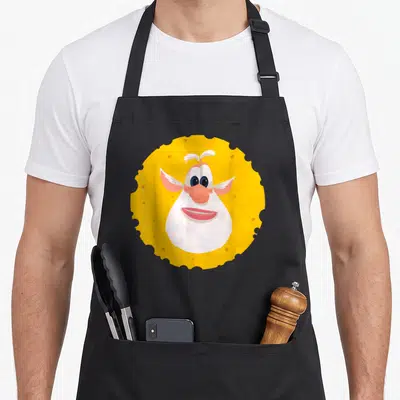 Tablier de cuisine noir avec un motif circulaire représentant un fromage anthropomorphique aux oreilles roses et au nez rose.