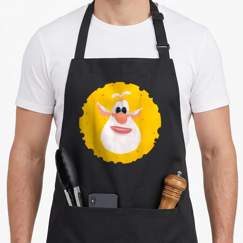 Tablier de cuisine noir avec un motif circulaire représentant un fromage anthropomorphique aux oreilles roses et au nez rose.