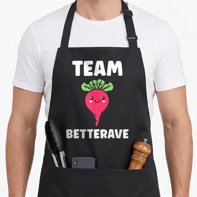 Tablier de cuisine noir avec illustration betterave rose souriante et texte blanc Team Betterave