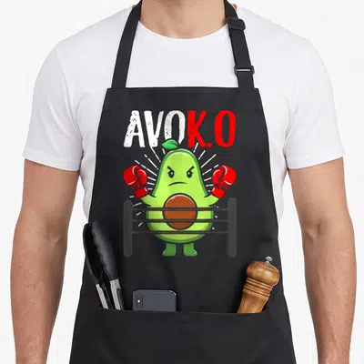 Tablier de cuisine noir avec un avocat vert portant des gants de boxe rouges dans un ring.
