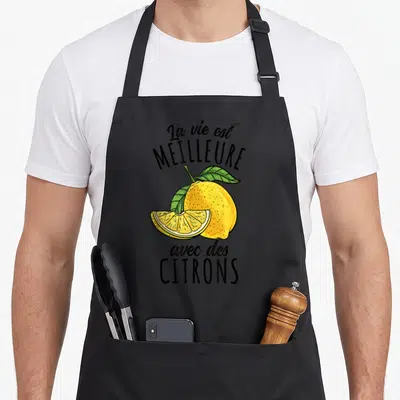 Tablier de cuisine noir avec illustration colorée d'un citron entier, d'une tranche et du texte La vie est meilleure avec des citrons.