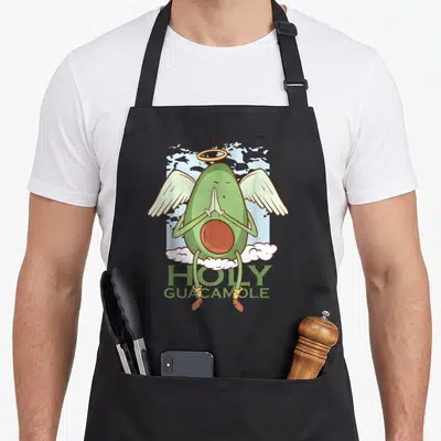Tablier de cuisine noir avec illustration d'un avocat vert en angelot priant sur des nuages.