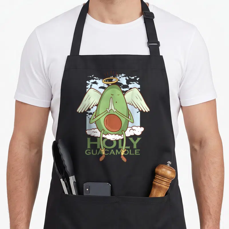 Tablier de cuisine noir avec illustration d'un avocat vert en angelot priant sur des nuages.