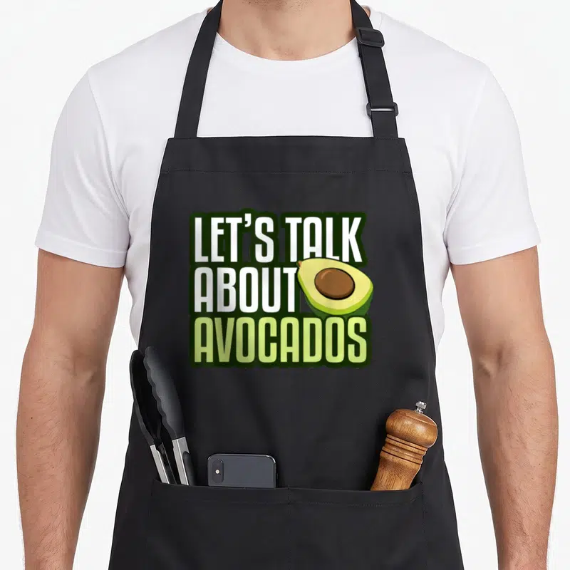 Tablier de cuisine noir avec inscription Let's talk about avocados et dessin d'avocat fendu en deux montrant son noyau.