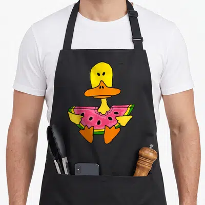 Tablier de cuisine noir avec un canard jaune tenant une tranche de pastèque rose et verte dans ses ailes.