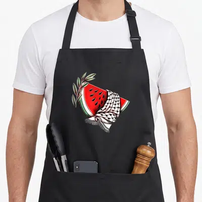 Tablier de cuisine noir avec une illustration de pastèque drapée d'un keffiyeh et d'une branche d'olivier.