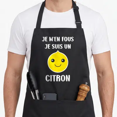 Tablier de cuisine noir avec un dessin de citron jaune souriant et le texte Je m'en fous je suis un Citron en blanc.