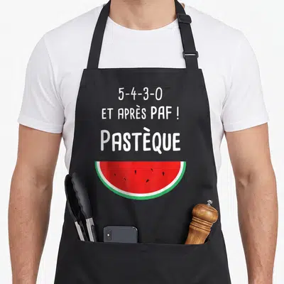 Tablier de cuisine noir avec l'inscription 5-4-3-0 et après PAF Pastèque au-dessus d'une demi-tranche de pastèque colorée.