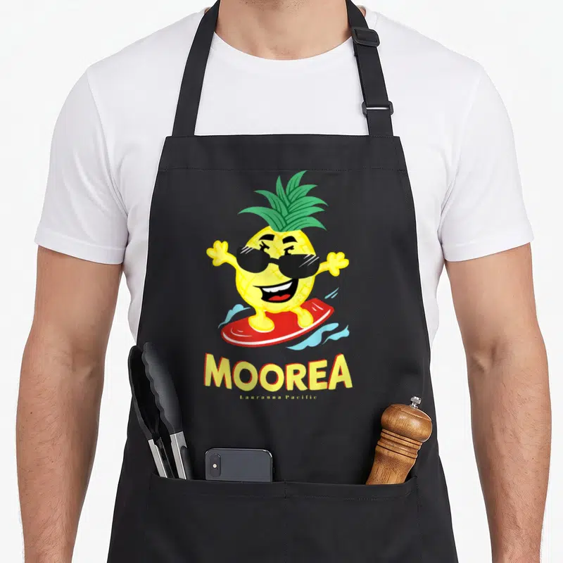 Tablier de cuisine noir avec un ananas surfeur jaune portant des lunettes noires et le texte Moorea en lettres jaunes.