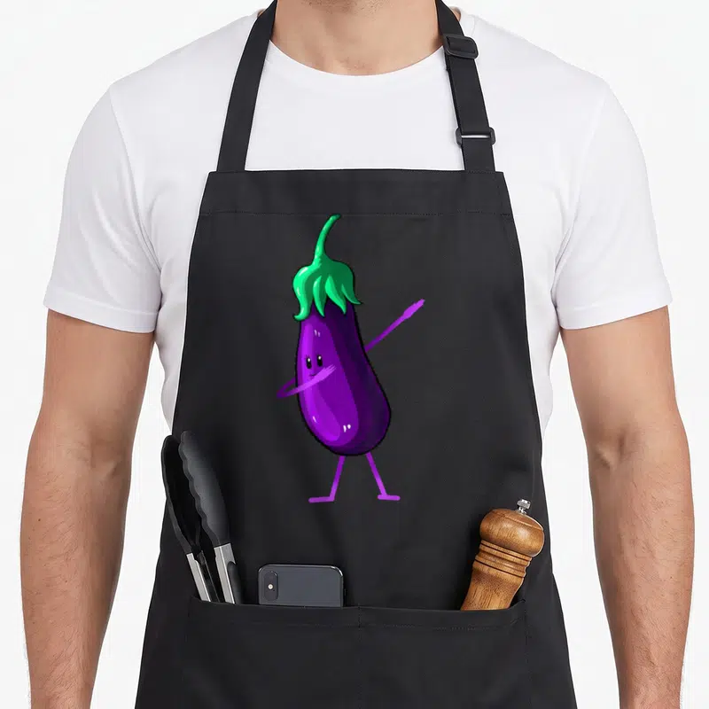 Tablier de cuisine noir avec illustration d'une aubergine violette aux bras et jambes stylisés posant avec assurance.