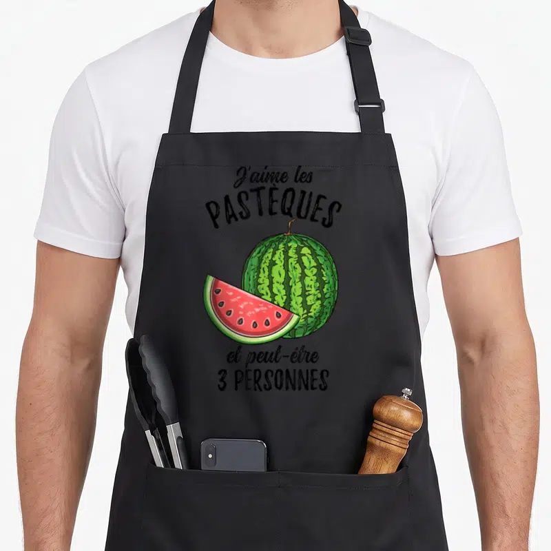 Tablier de cuisine noir avec illustration d'une pastèque entière, d'une tranche rose et texte humoristique en noir.