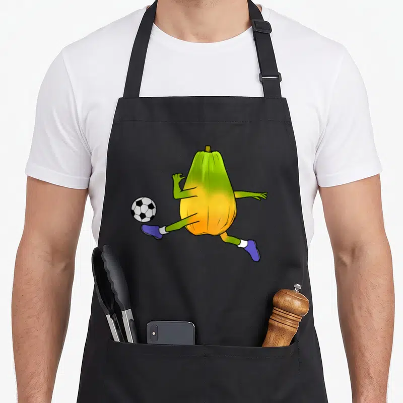 Tablier de cuisine noir avec une papaye verte et jaune jouant au soccer en chaussettes blanches et bottes violettes.