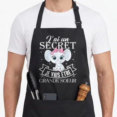 Tablier de cuisine noir avec éléphant rose et texte J'ai un secret je vais être grande sœur