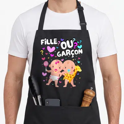 Tablier de cuisine noir avec deux bébés illustrés et le texte Fille ou Garçon entouré de cœurs colorés.