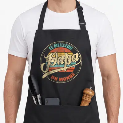 Tablier de cuisine noir avec logo circulaire retro et texte Le Meilleur Papa Du Monde en lettres dorées et colorées.