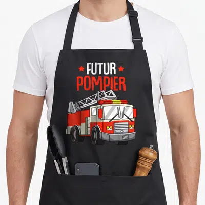 Tablier de cuisine noir avec illustration de camion de pompier rouge et texte futur pompier en lettres blanches et rouges.