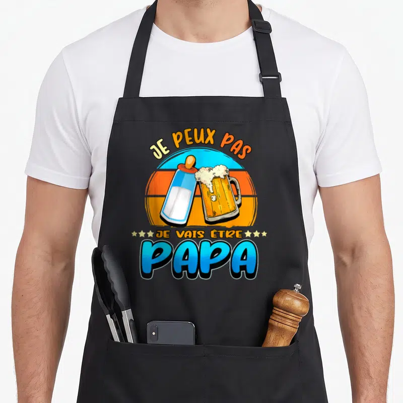 Tablier de cuisine noir avec un biberon et une bière s'entrechoquant sur fond rétro orange et bleu.
