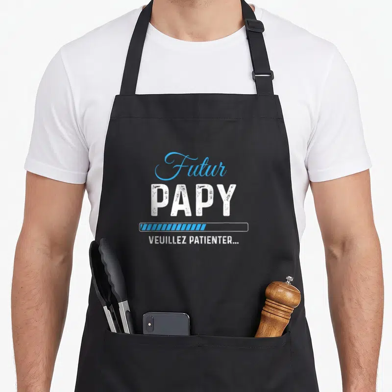 Tablier de cuisine noir avec inscription Futur Papy et barre de progression bleue.