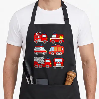 Tablier de cuisine noir avec six illustrations de camions de pompier rouges, d'échelles et de gyrophares bleus disposées en grille.
