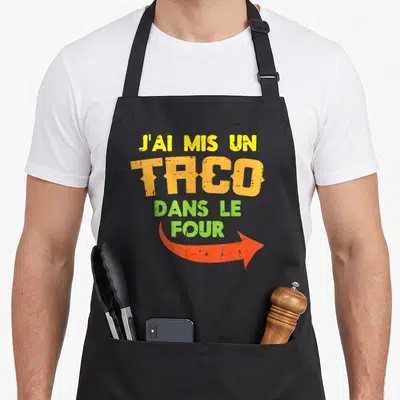 Tablier de cuisine noir avec inscription colorée J'ai mis un taco dans le four et flèche orange.