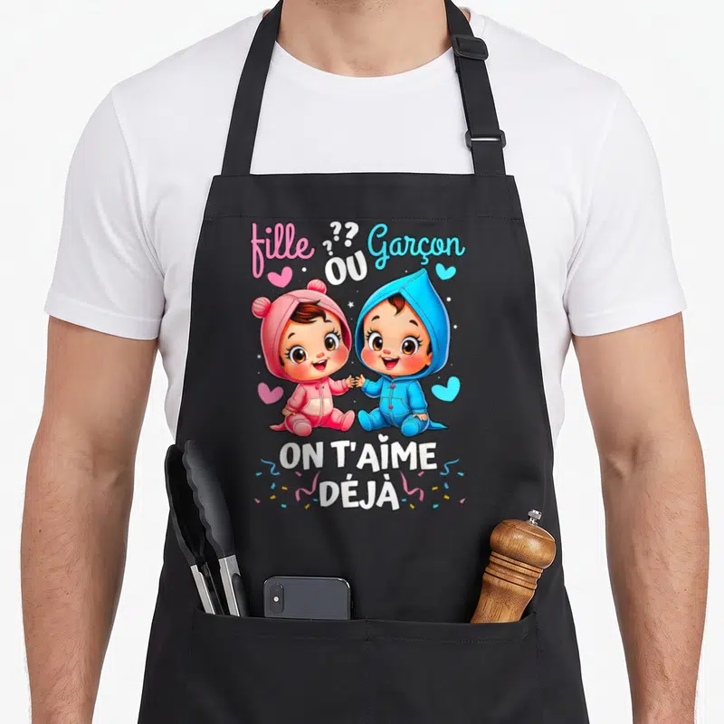 Tablier de cuisine noir avec illustration de bébés rose et bleu tenant la main sous le texte On T'Aime Déjà.