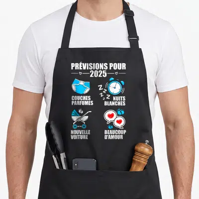 Tablier de cuisine noir avec illustration colorée annonçant les prévisions pour 2025 incluant un réveil et une poussette.