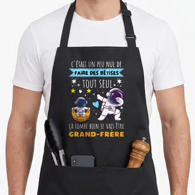 Tablier de cuisine noir avec deux astronautes et le texte C'était un peu nul de faire des bêtises tout seul.