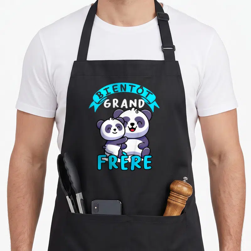 Tablier de cuisine noir avec illustration de deux pandas et le texte Bientôt Grand Frère en bleu et blanc.