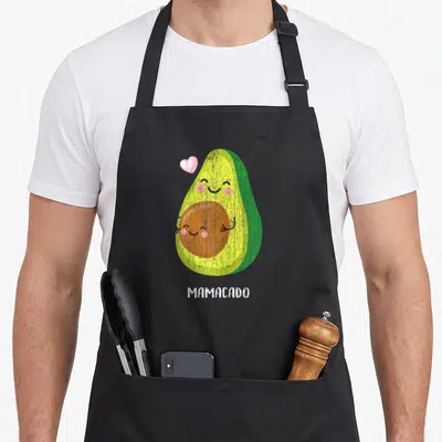Tablier de cuisine noir avec un avocado souriant, un cœur rose et l'inscription Mamacado en bas.
