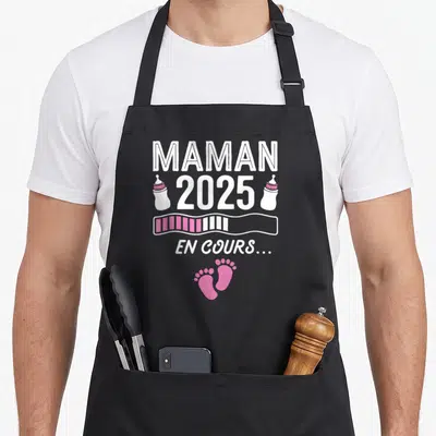 Tablier de cuisine noir avec l'inscription Maman 2025 En cours et des motifs roses