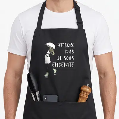 Tablier de cuisine noir avec une femme enceinte sous un parapluie et le texte J'peux pas je suis enceinte