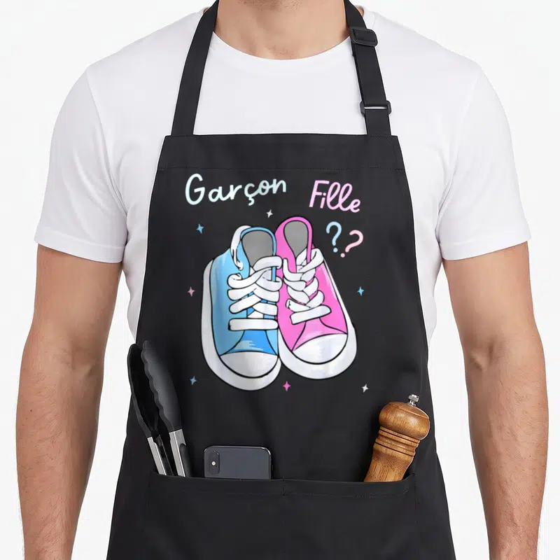 Tablier de cuisine noir avec illustration de deux baskets bleu et rose et le texte Garçon Fille ?
