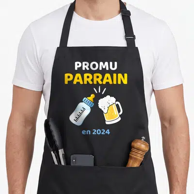 Tablier de cuisine noir avecPromu Parrainen 2024 illustré par un biberon et une bière qui s'entrechoquent.