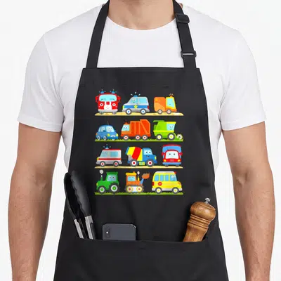 Tablier de cuisine noir avec douze véhicules colorés à visages souriants alignés en quatre rangées.