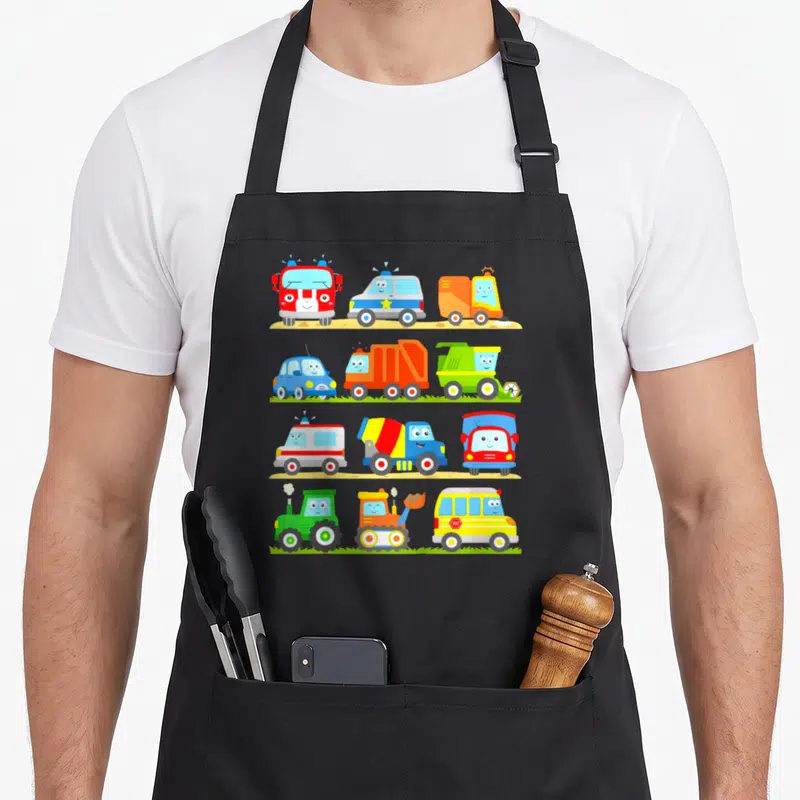 Tablier de cuisine noir avec douze véhicules colorés à visages souriants alignés en quatre rangées.