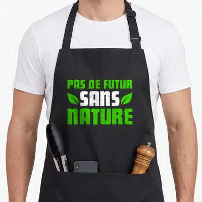 Tablier de cuisine noir avec l'inscription Pas de futur sans nature entourée de deux feuilles vertes stylisées.